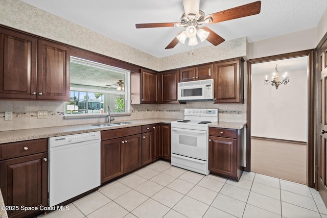 kitchen featuring white appliances, a sink, tasteful backsplash, and light countertops