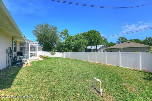 view of yard with a lanai and a fenced backyard
