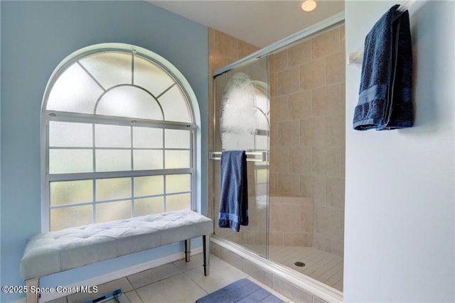 full bathroom with tile patterned flooring and tiled shower