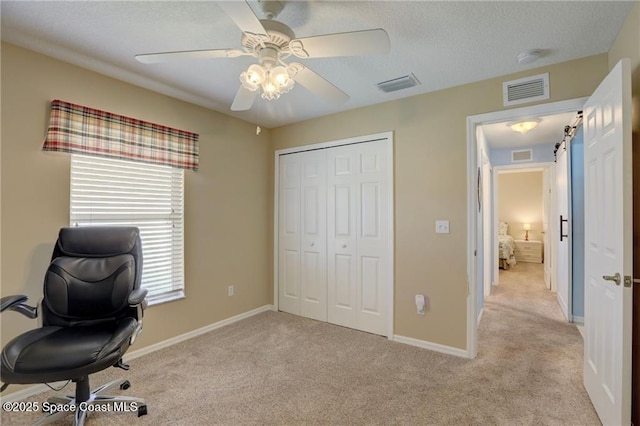 unfurnished office featuring light colored carpet, ceiling fan, and visible vents