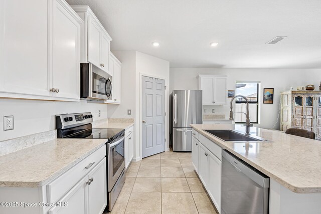 413 Catfish Pl, Cocoa, FL 32927 - kitchen with visible vents, an island with sink, white cabinets, a sink, and appliances with stainless steel finishes