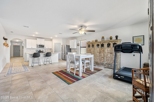413 Catfish Pl, Cocoa, FL 32927 - dining room with arched walkways, a ceiling fan, baseboards, light tile patterned floors, and visible vents