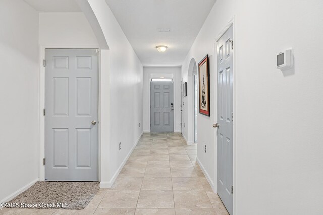 413 Catfish Pl, Cocoa, FL 32927 - hall with arched walkways, baseboards, and light tile patterned floors