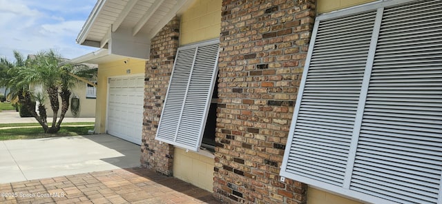 details featuring a heating unit, brick siding, and driveway