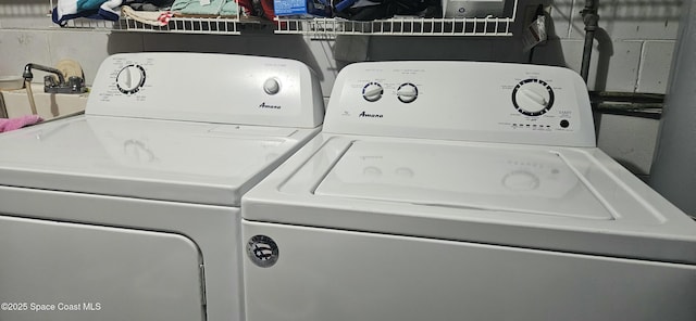clothes washing area featuring laundry area and washer and clothes dryer