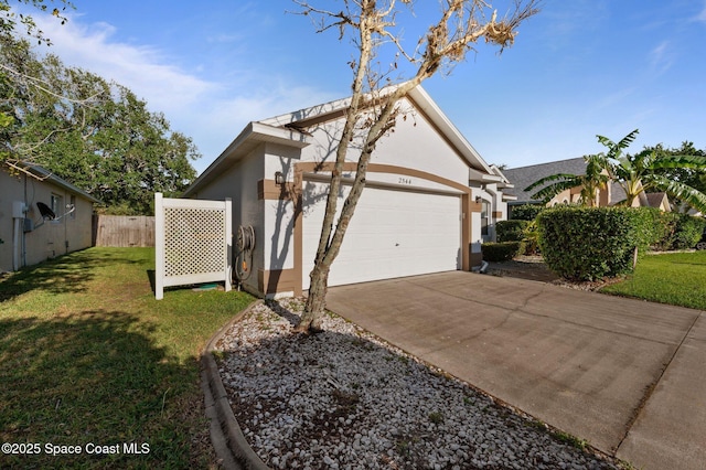 2544 Ventura Cir, Melbourne, FL 32904 - view of home's exterior with a lawn, a garage, fence, stucco siding, and driveway