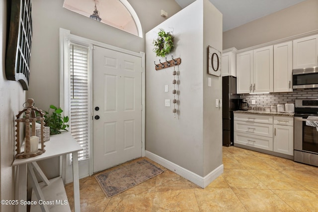 2544 Ventura Cir, Melbourne, FL 32904 - entryway with baseboards and light tile patterned flooring