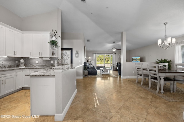 2544 Ventura Cir, Melbourne, FL 32904 - kitchen featuring white cabinets, ceiling fan with notable chandelier, backsplash, and light stone counters