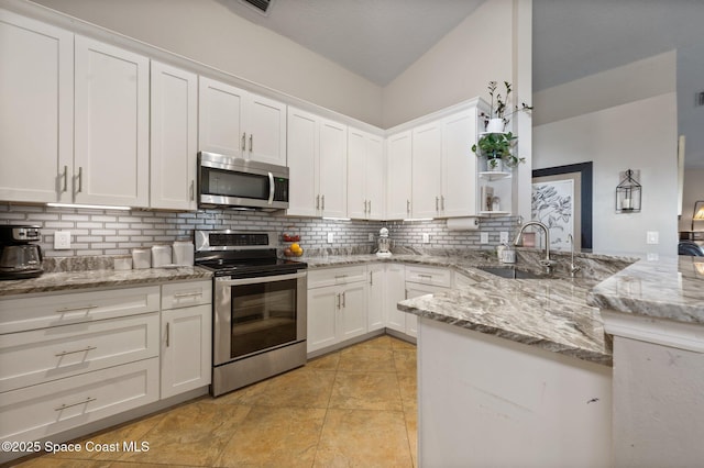 2544 Ventura Cir, Melbourne, FL 32904 - kitchen with tasteful backsplash, a peninsula, white cabinets, appliances with stainless steel finishes, and a sink