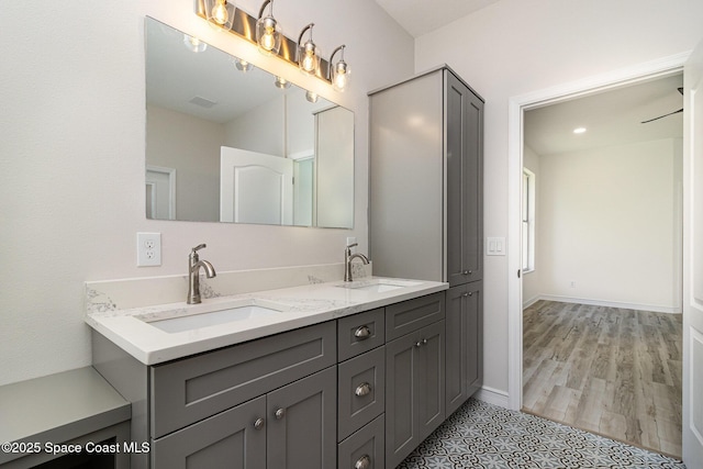 full bath with double vanity and baseboards