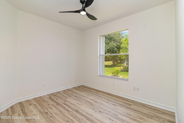empty room with light wood-type flooring, a ceiling fan, and baseboards