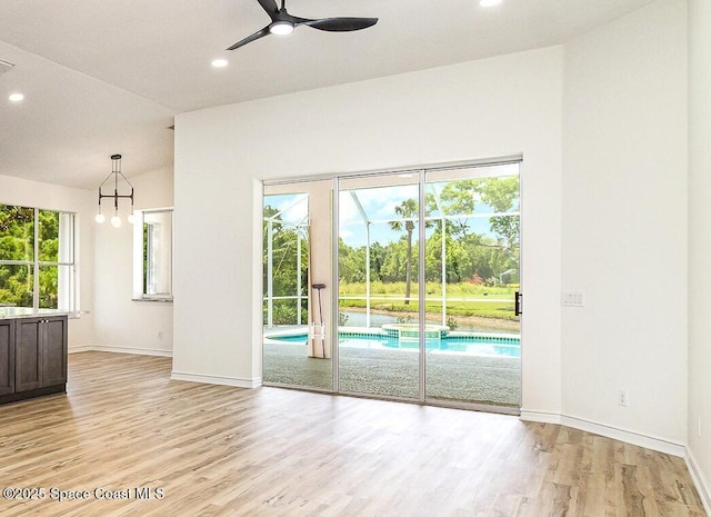 spare room with vaulted ceiling, ceiling fan, light wood-style flooring, baseboards, and recessed lighting