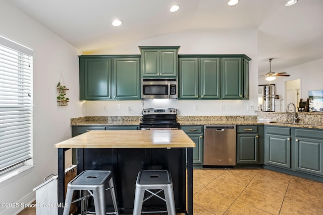 kitchen featuring green cabinetry, appliances with stainless steel finishes, a sink, and wooden counters