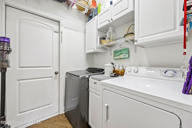 clothes washing area featuring cabinet space, tile patterned flooring, and independent washer and dryer
