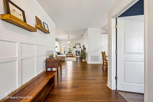 corridor featuring visible vents and dark wood-style floors