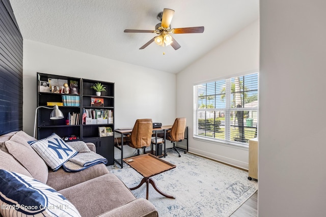 home office featuring ceiling fan, lofted ceiling, wood finished floors, and baseboards