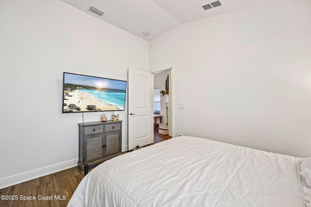 bedroom with vaulted ceiling, visible vents, baseboards, and dark wood-style flooring
