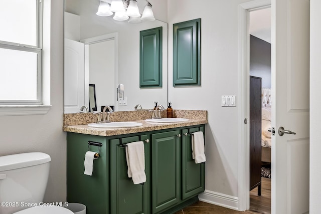 full bath featuring double vanity, ensuite bath, toilet, and a sink