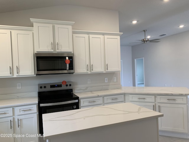 kitchen with appliances with stainless steel finishes, white cabinets, and visible vents