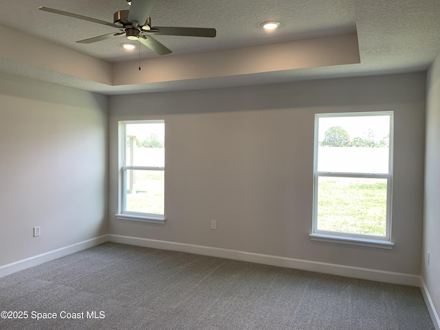 empty room featuring carpet floors, a textured ceiling, ceiling fan, and baseboards