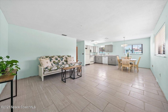 living area with visible vents and a textured ceiling