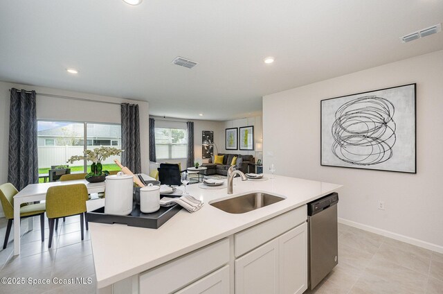 kitchen with visible vents, white cabinets, dishwasher, a sink, and open floor plan