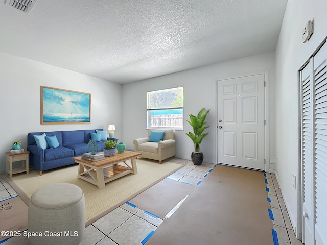 335 N Brevard Ave, Cocoa Beach, FL 32931 - living room with tile patterned flooring, a textured ceiling, and visible vents
