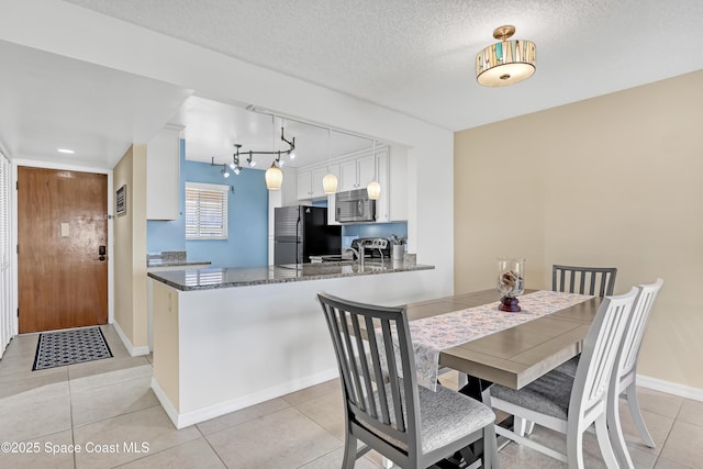 3150 N Harbor City Blvd Unit 236, Melbourne, FL 32935 - dining space featuring light tile patterned floors, baseboards, rail lighting, and a textured ceiling
