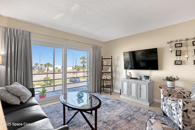 3150 N Harbor City Blvd Unit 236, Melbourne, FL 32935 - living area with a textured ceiling, light tile patterned floors, and baseboards