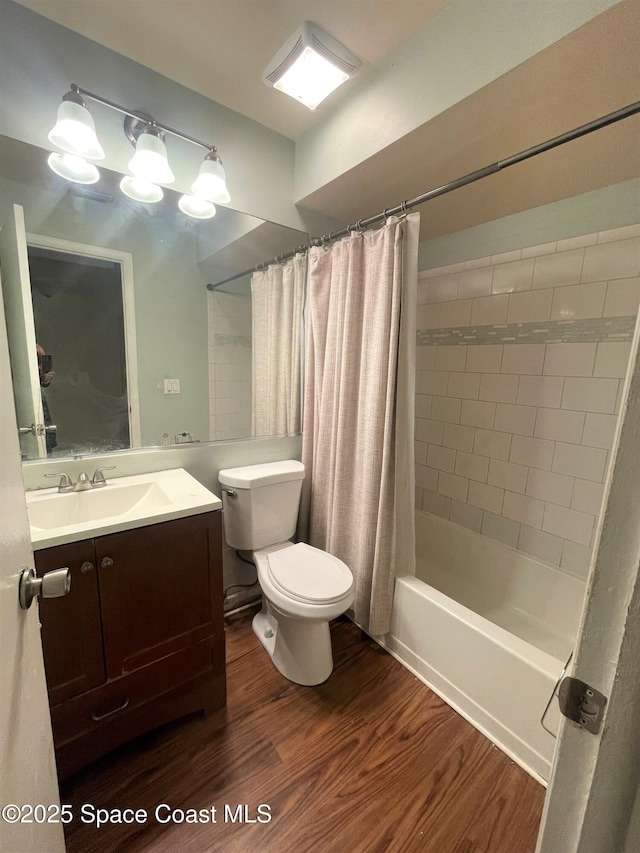 full bathroom featuring shower / bath combination with curtain, wood finished floors, vanity, and toilet