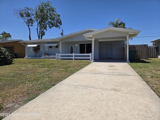 ranch-style home featuring concrete driveway, a front yard, fence, and an attached carport