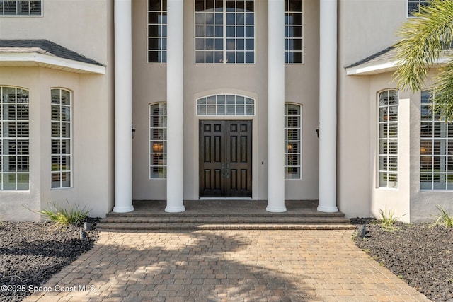 entrance to property featuring stucco siding