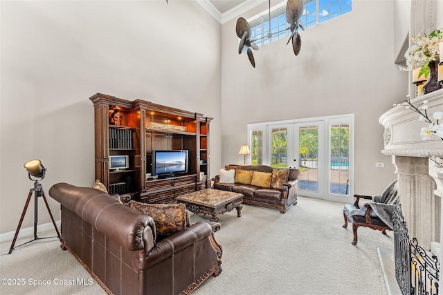 living room featuring carpet, ornamental molding, a towering ceiling, french doors, and baseboards