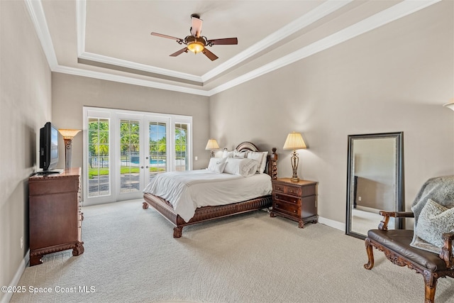 carpeted bedroom featuring access to outside, a raised ceiling, french doors, ornamental molding, and baseboards