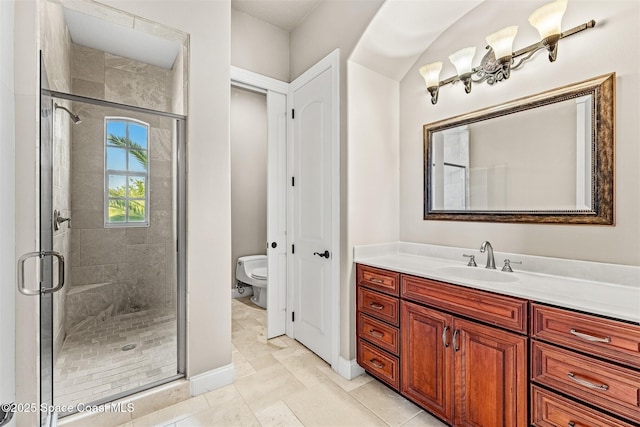 bathroom featuring a stall shower, toilet, vanity, and marble look tiles