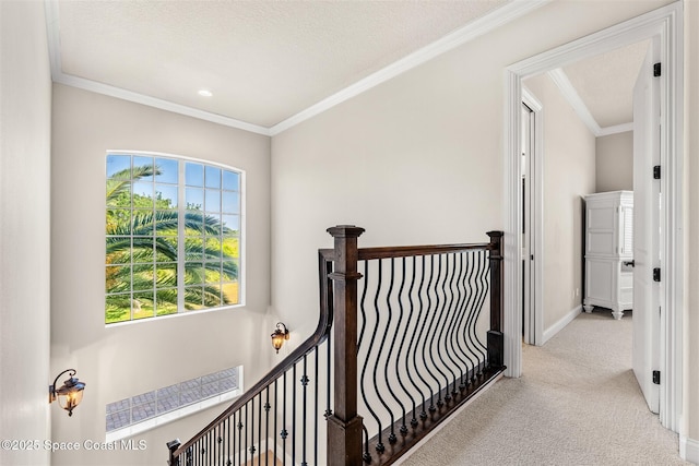 hall with carpet floors, crown molding, an upstairs landing, and baseboards