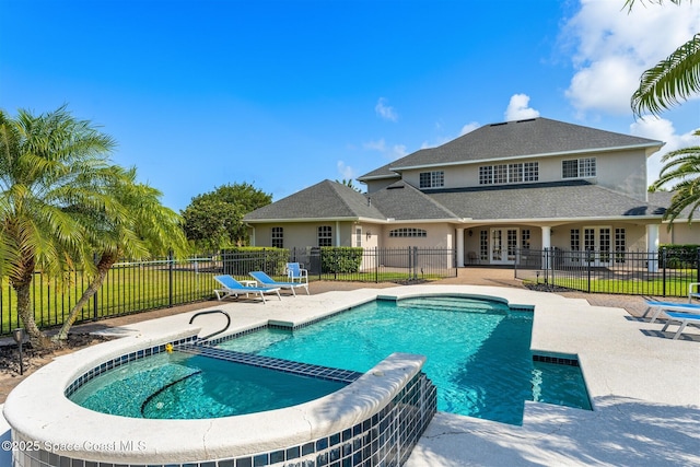 view of pool featuring french doors, a patio area, fence, and a pool with connected hot tub