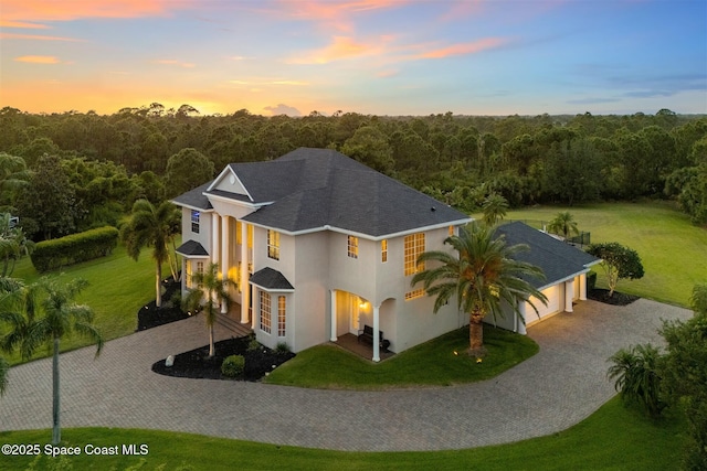 view of front of property with driveway, stucco siding, and a front yard