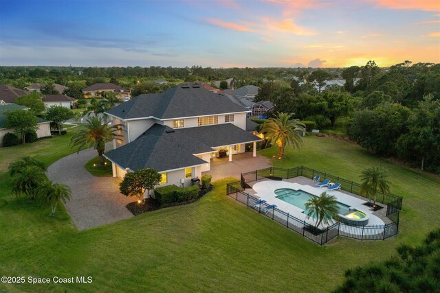 aerial view at dusk of view of pool area