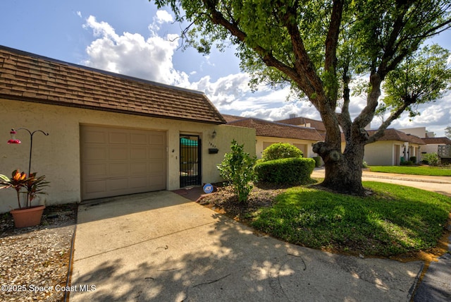 view of front facade featuring concrete driveway, stucco siding, and a garage