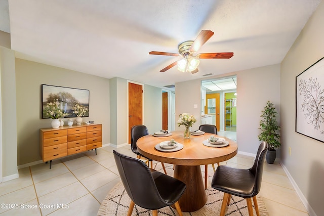 dining space with light tile patterned floors, ceiling fan, visible vents, and baseboards