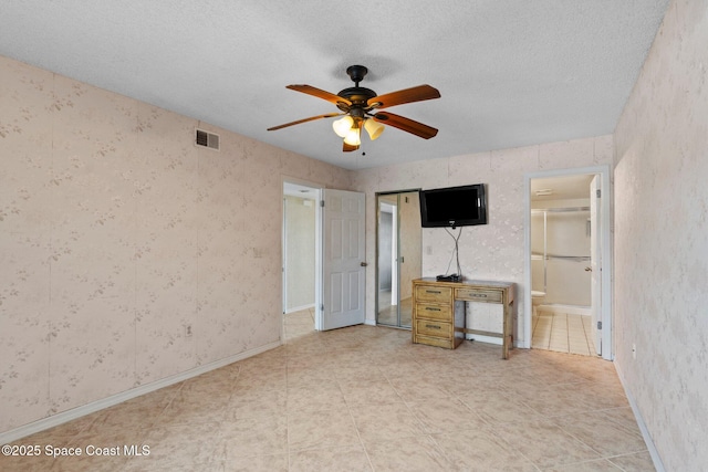 5801 N Banana River Blvd Unit 936, Cape Canaveral, FL 32920 - unfurnished bedroom featuring connected bathroom, tile patterned floors, ceiling fan, visible vents, and a textured ceiling