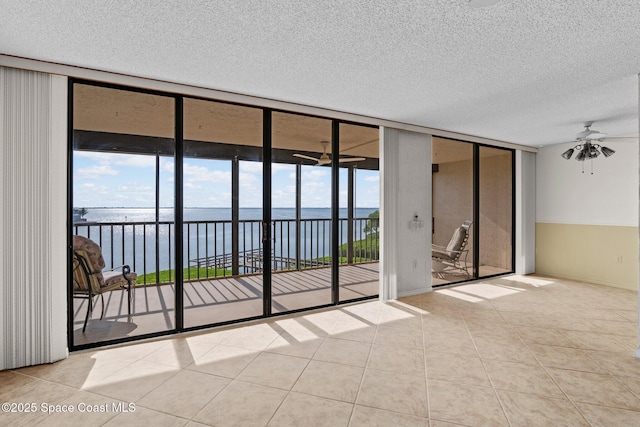 5801 N Banana River Blvd Unit 936, Cape Canaveral, FL 32920 - tiled empty room featuring a textured ceiling, a water view, floor to ceiling windows, and a ceiling fan