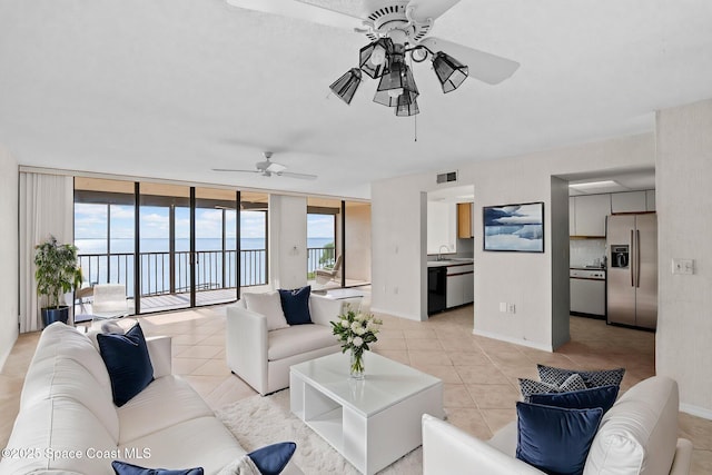 5801 N Banana River Blvd Unit 936, Cape Canaveral, FL 32920 - living area with light tile patterned floors, a ceiling fan, expansive windows, and baseboards