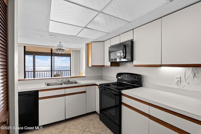 5801 N Banana River Blvd Unit 936, Cape Canaveral, FL 32920 - kitchen featuring black appliances, a sink, white cabinets, and light countertops