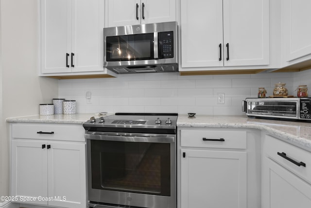 1954 Crossbill Dr, Titusville, FL 32796 - kitchen featuring stainless steel appliances, tasteful backsplash, white cabinets, and a toaster