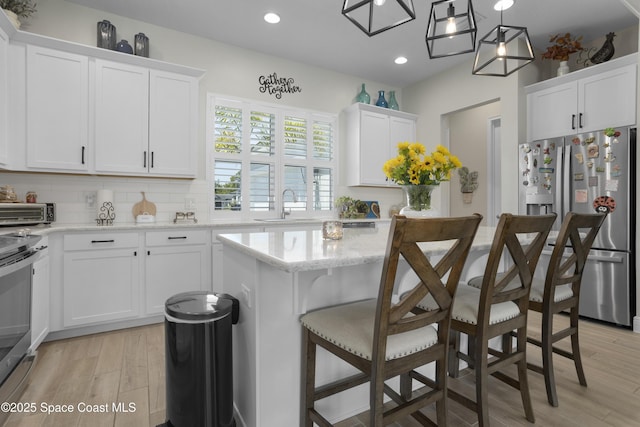 1954 Crossbill Dr, Titusville, FL 32796 - kitchen featuring recessed lighting, a kitchen island, white cabinetry, and appliances with stainless steel finishes