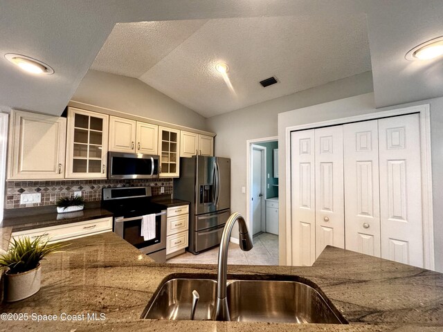 302 Periwinkle Dr, Sebastian, FL 32958 - kitchen with visible vents, a sink, appliances with stainless steel finishes, backsplash, and lofted ceiling