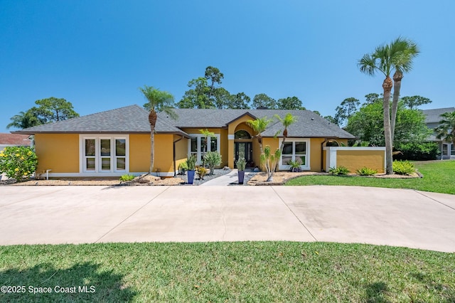 ranch-style home with stucco siding, french doors, and a front yard
