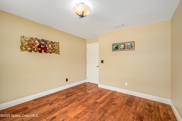 unfurnished room featuring baseboards and wood finished floors